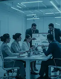  Executive team of professionals in their 30s analyzing business charts and data in a modern, high-tech boardroom