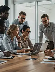  Diverse team of payroll professionals in their 40s analyzing charts and data on laptops in a collaborative boardroom setting
