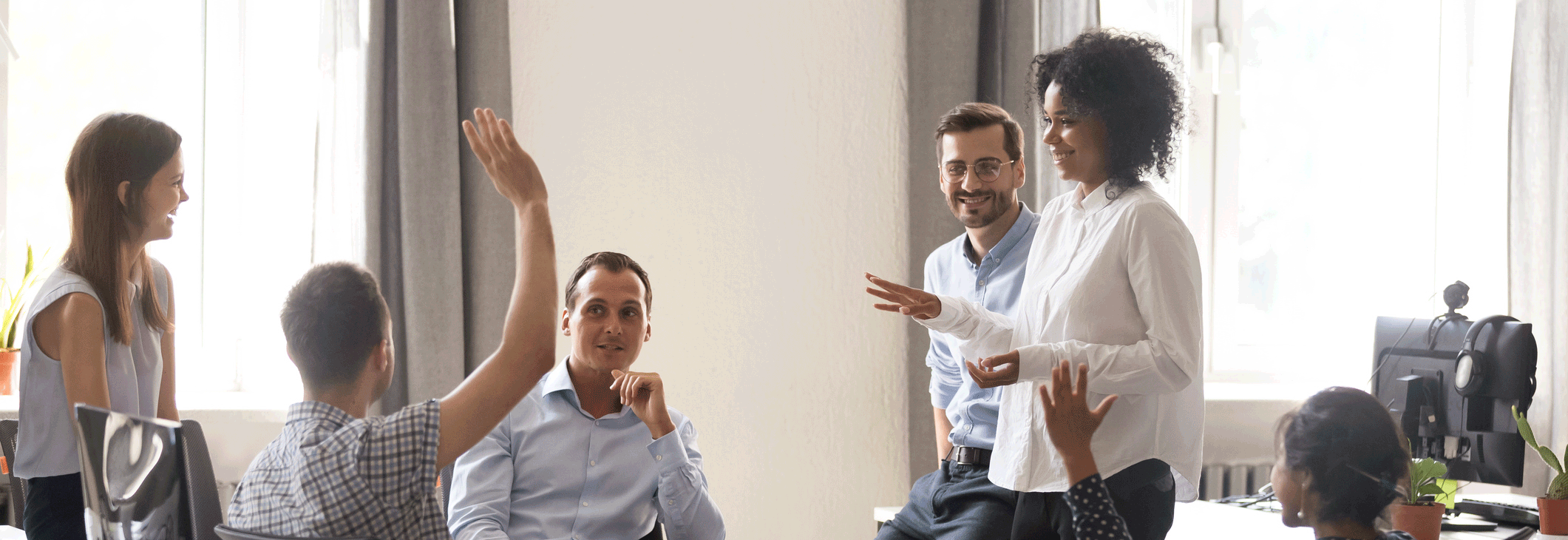 we can see a group of people at a office discussion and people raising ther hands to answer questions