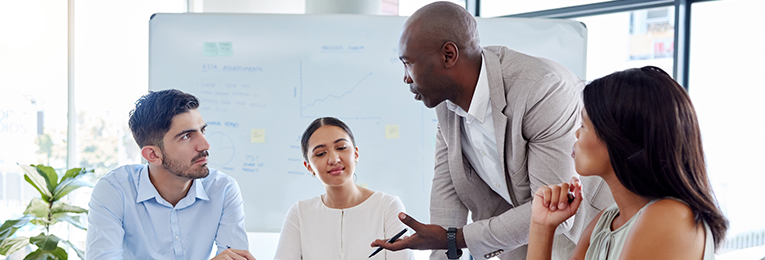 four people at a office meeting at a board room
