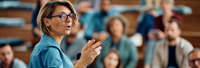 we can see a women leader addressing a staff meeting
