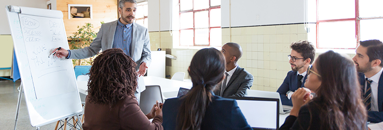 we can see a leader addressing a few people at a Coaching-And-Mentoring session at a office space