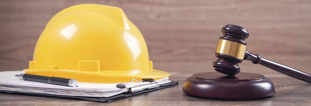 we can see a contracter helmet, agreement and a court hammer placed on a table